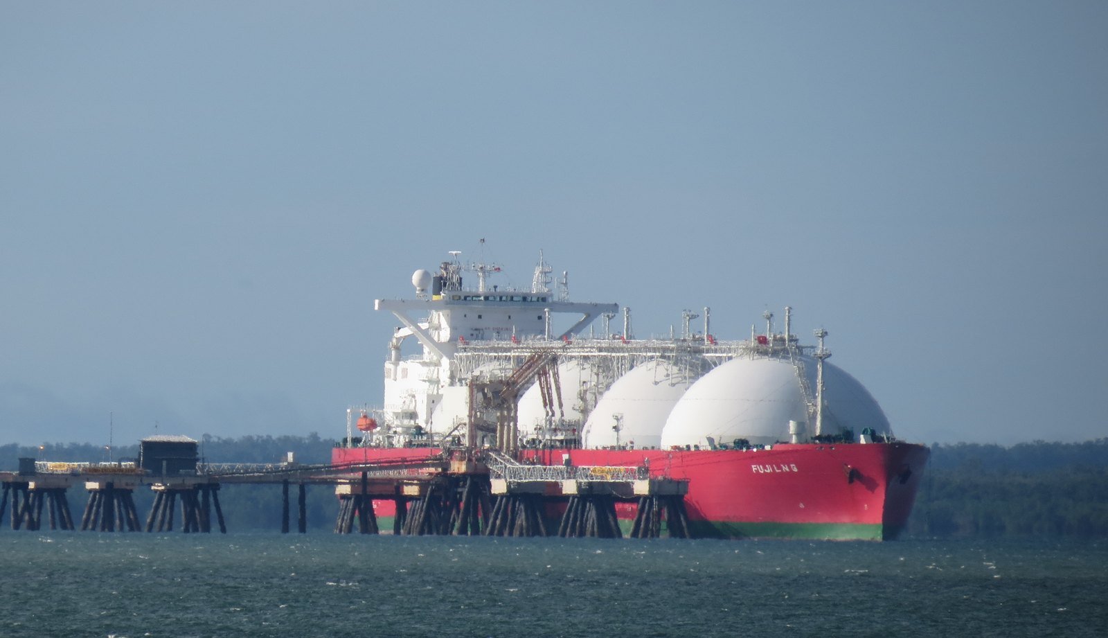 LPG gas carrier with white spherical tanks at a coastal jetty